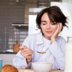 a woman sitting at a table with a plate of food